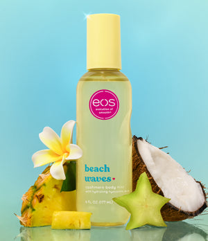 EOS Beach Waves body mist bottle with tropical fruits on a blue background