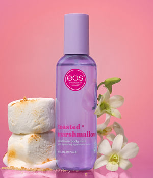 EOS Toasted Marshmallow body mist bottle with marshmallows and flowers on a pink background