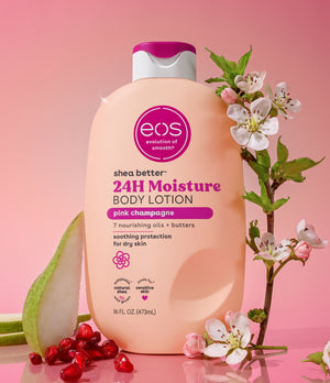 EOS shea butter 24H Moisture body lotion bottle with pink champagne flavor on a pink background with flowers and pomegranate seeds.