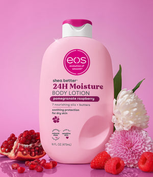 Pink bottle of eos body lotion with pomegranate raspberry flavor on a pink background with flowers and fruits.