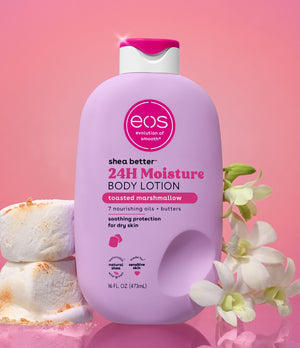 EOS shea butter 24H Moisture body lotion bottle with marshmallows and flowers on a pink background