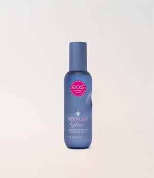 A bottle of EOS Cotton Candy body mist in a blue bottle with a matching cap, set against a plain off-white background.