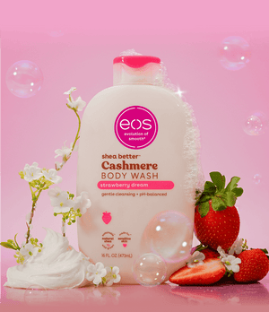 eos shea butter Cashmere Body Wash with strawberries and flowers on a pink background
