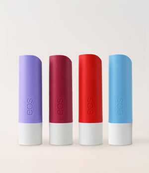 Four eos lip balm tubes in purple, red, white, and blue on a light gray background