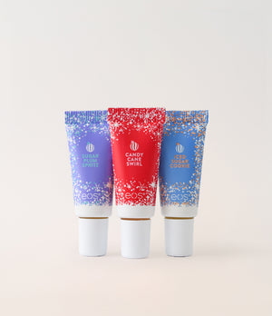 Three EOS lip balm tubes with colorful labels on a light gray background