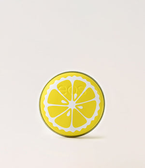 Round yellow object with lemon slice design on a light beige background